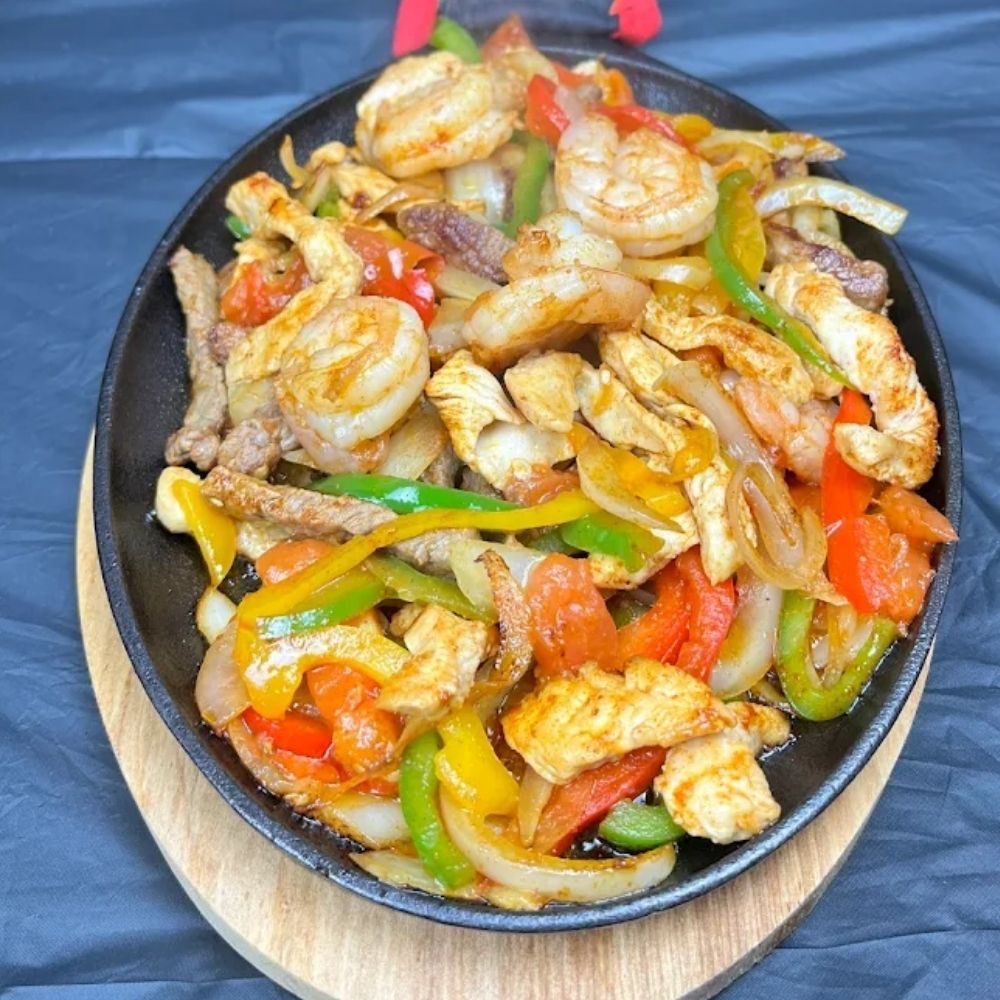 A sizzling skillet of shrimp and chicken fajitas with peppers and onions